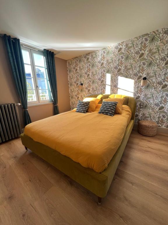 a bedroom with a large bed with yellow sheets and pillows at Maison d'hôtes de la prison en toutes libertés in Espalion