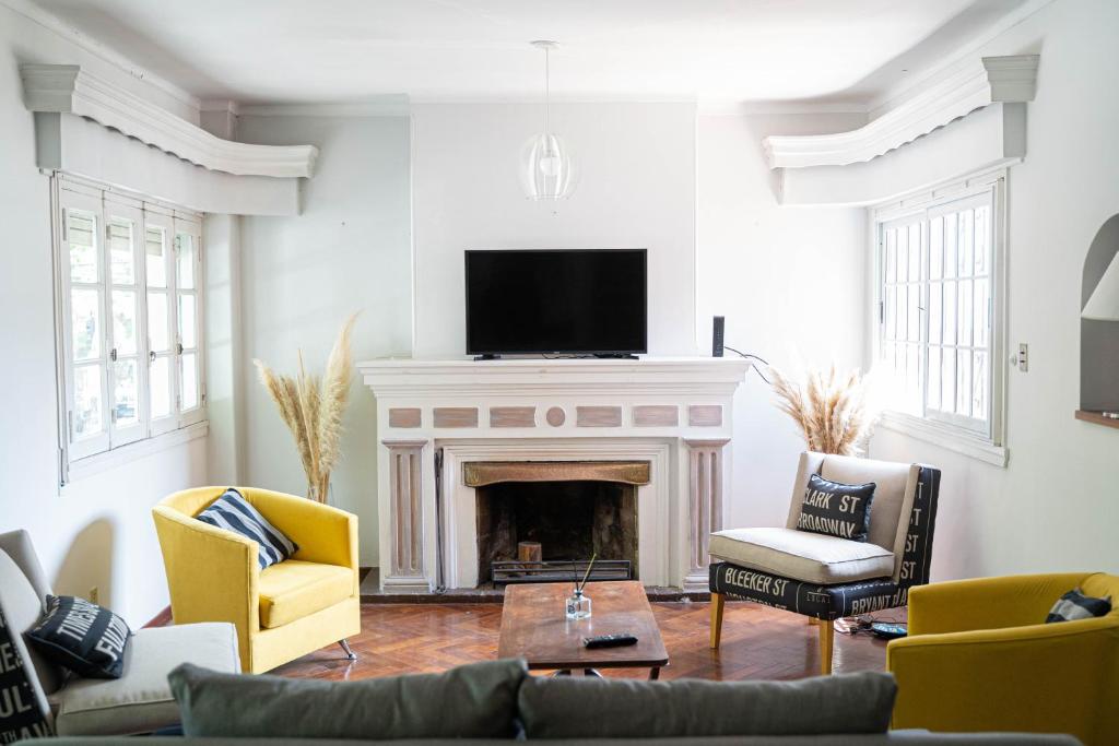 a living room with a fireplace and a tv at Amplio y elegante chalet en la mejor zona de Mendoza in Mendoza