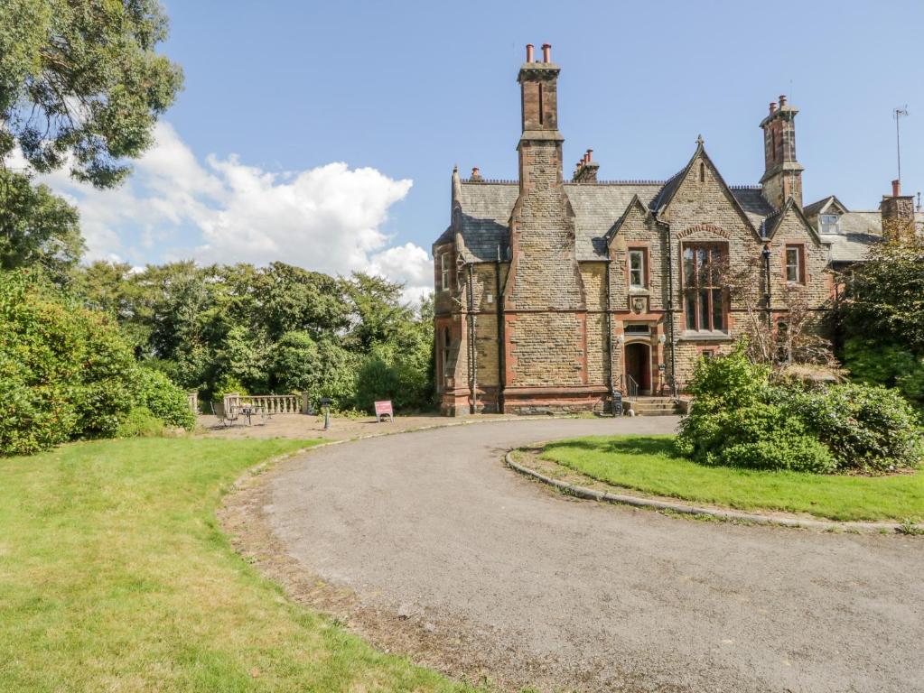 an old stone house with a winding road at Millwood Manor in Barrow in Furness