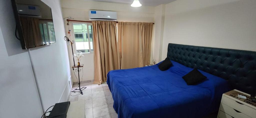 Esmeralda Apartment في بوينس آيرس: غرفة نوم بسرير ازرق في غرفة