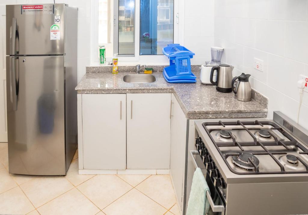 uma cozinha com um frigorífico de aço inoxidável e um lavatório em Flamingo Naks Suite (Malindi's Hidden Gem) em Malindi