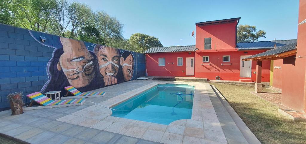 un mural en el lado de una casa con piscina en Mi lugar Serrano 3 en Valle Hermoso