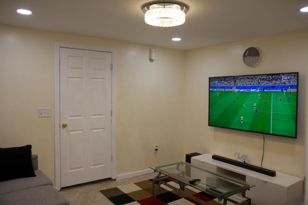 uma sala de estar com uma televisão de ecrã plano na parede em Mamas Love Apartment em Newark