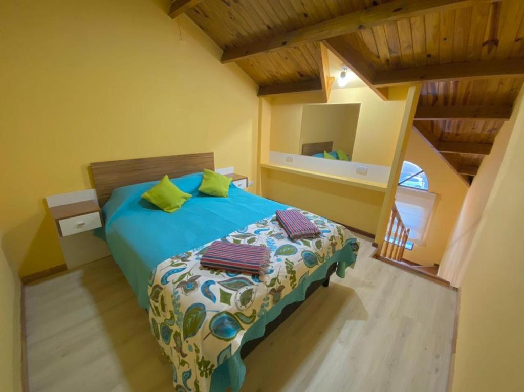 Un dormitorio con una cama azul con almohadas verdes en Cielo Sureño en Río Gallegos