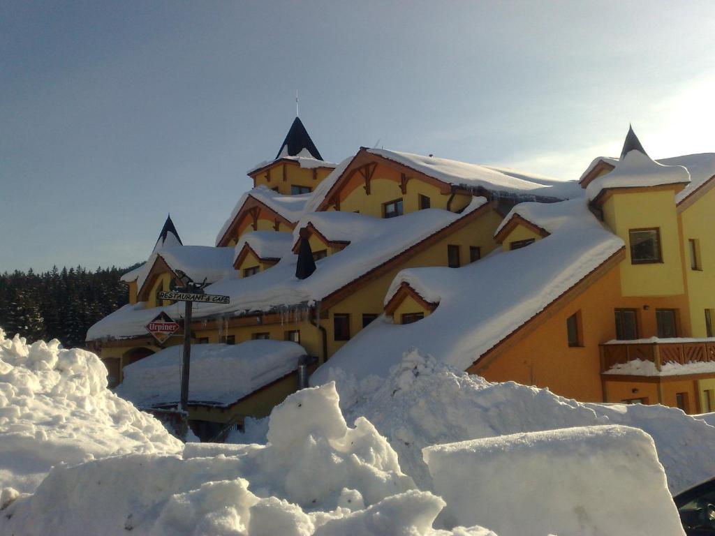 a building covered in snow with a pile of snow at Apartmány Donovaly in Donovaly