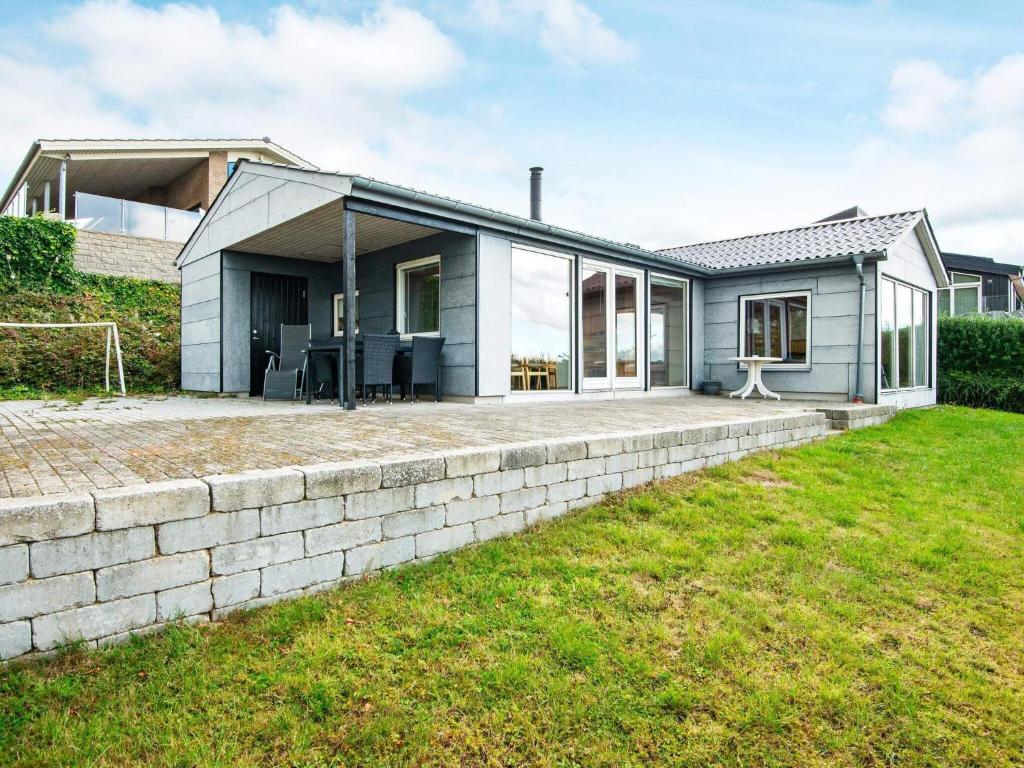 a home with a brick retaining wall and a house at 4 person holiday home in Aabenraa-By Traum in Aabenraa