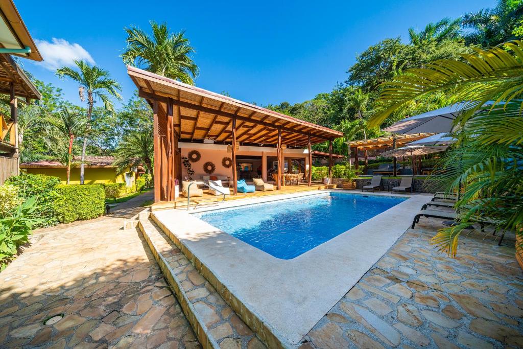 a villa with a swimming pool and a pavilion at Hotel Arco Iris in Tamarindo