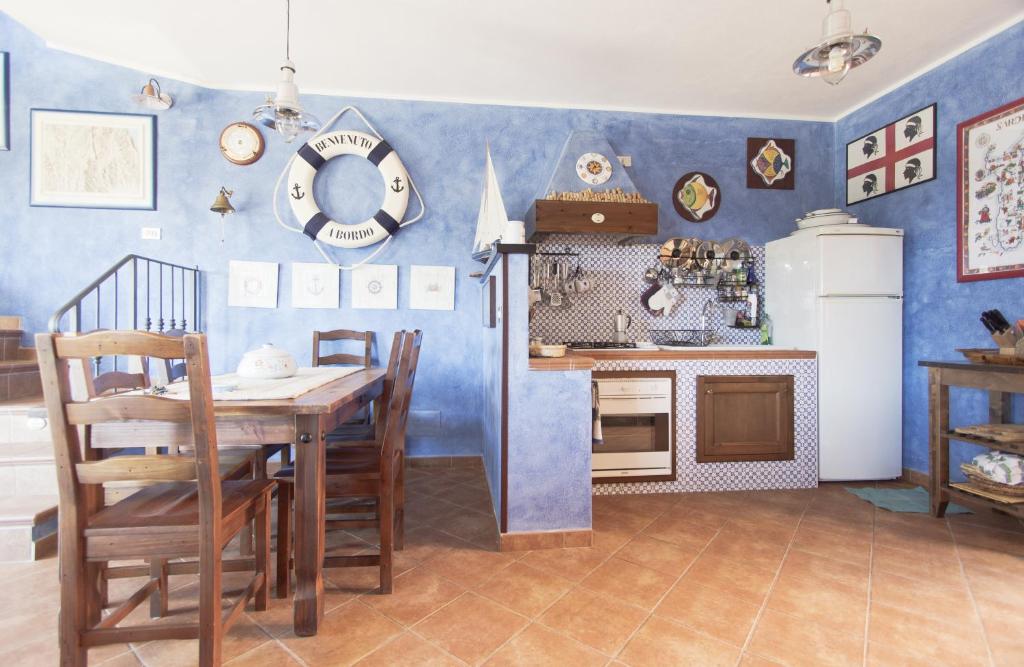 una cucina con tavolo e parete blu di Marine House a Cala Gonone
