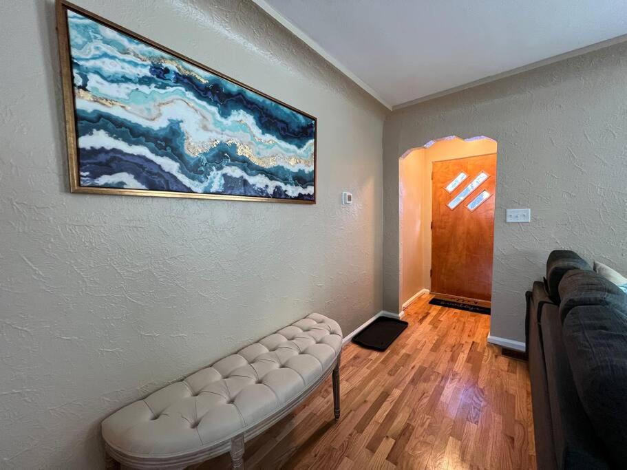 uma sala de estar com um sofá e uma pintura na parede em Snug, neighborly home perfect for your small group em Billings