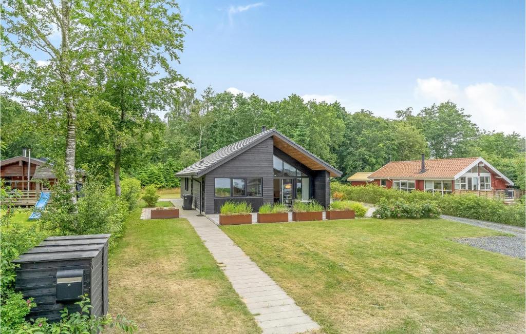 een huis met een zwart dak en een tuin bij Awesome Home In Sunds With Lake View in Sunds