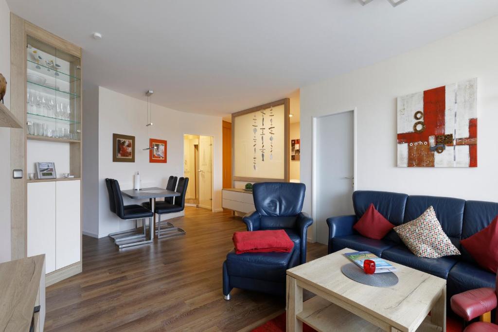 uma sala de estar com um sofá azul e uma mesa em Trafalgar 125 em Döse