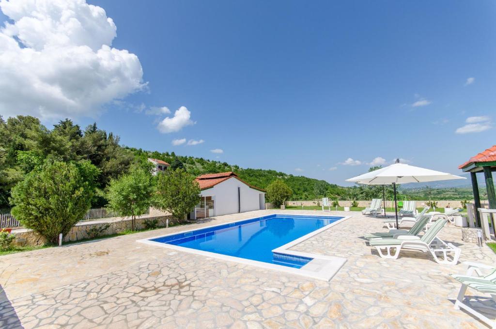 a villa with a swimming pool and patio furniture at Villa Ana in Umljanović