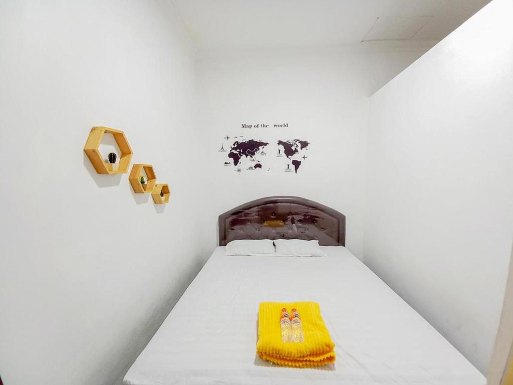 - une chambre avec un lit doté d'une couverture jaune dans l'établissement Homestay Bahari near Wisata Bahari Tlocor Sidoarjo Mitra RedDoorz, à Bangil