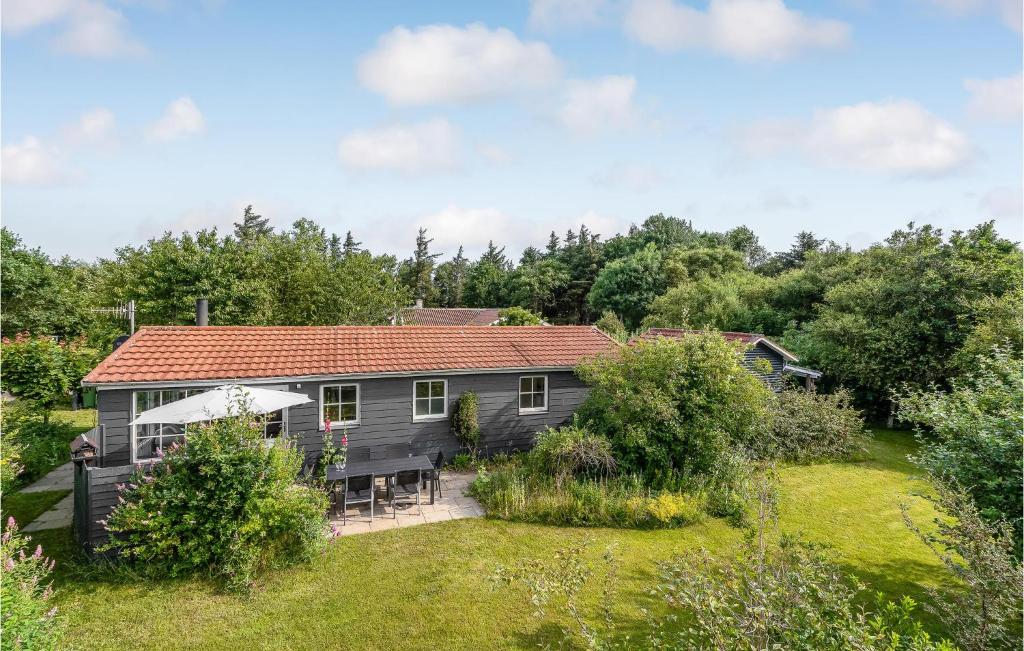 una casa gris con techo rojo y patio en Beautiful Home In Vinderup With Kitchen, en Vinderup