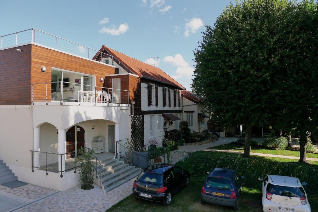a house with two cars parked in front of it at Apartment L'Aquarius in Villeneuve-le-Roi