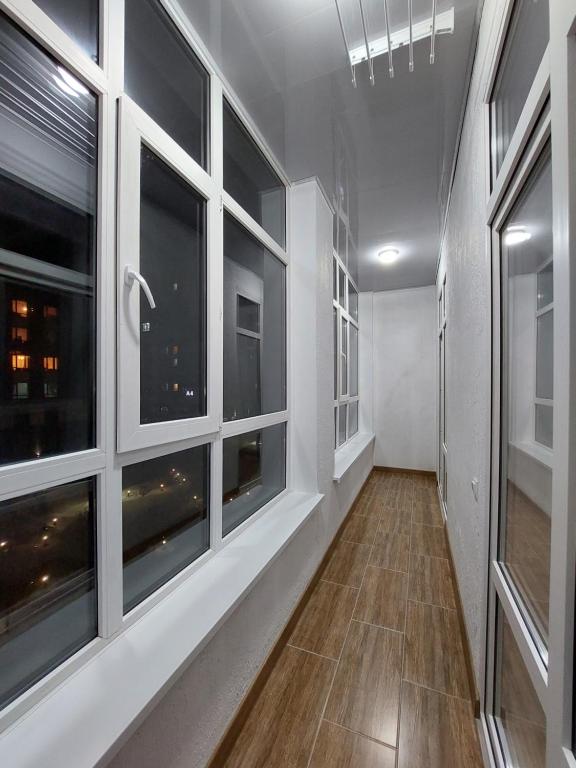a hallway with large windows and a hard wood floor at Аппартаменты рядом с ЭКСПО in Astana