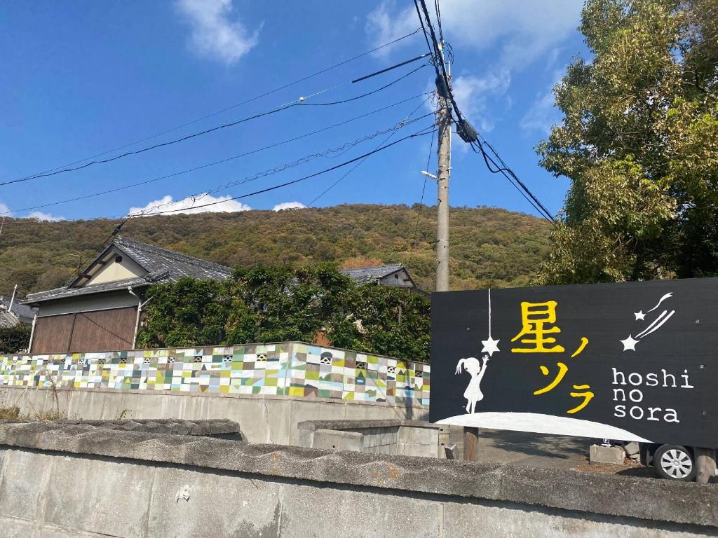 un panneau pour un broussail sans panneau de savon sur un mur dans l'établissement 星ノソラ, à Shodoshima