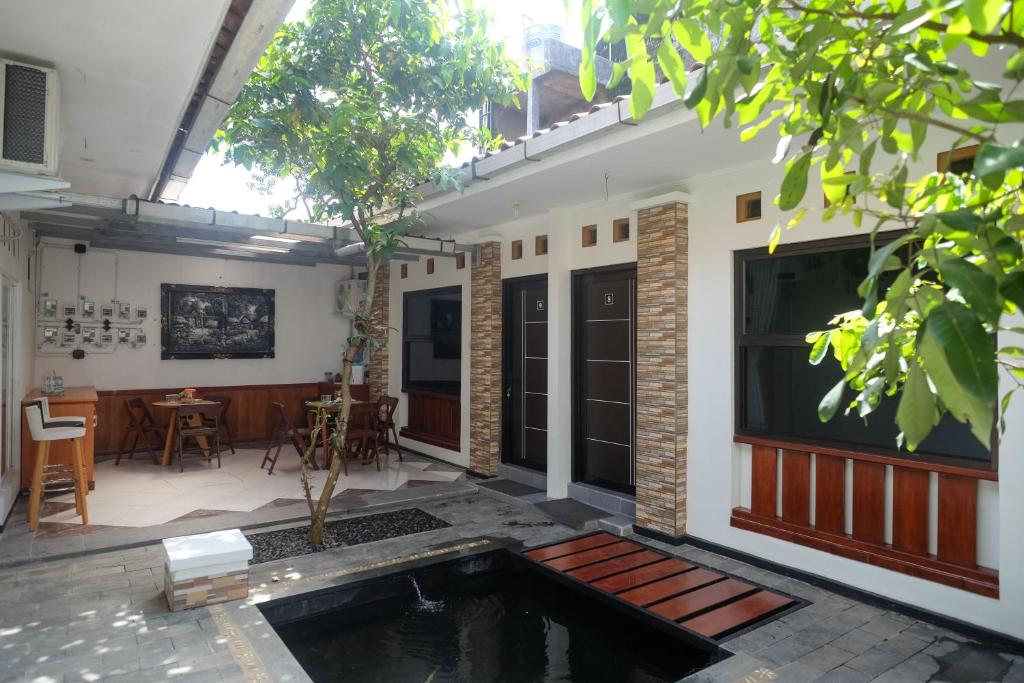 una casa con piscina en medio de un patio en RedDoorz Syariah near Kampus UNSOED Purwokerto, en Banyumas