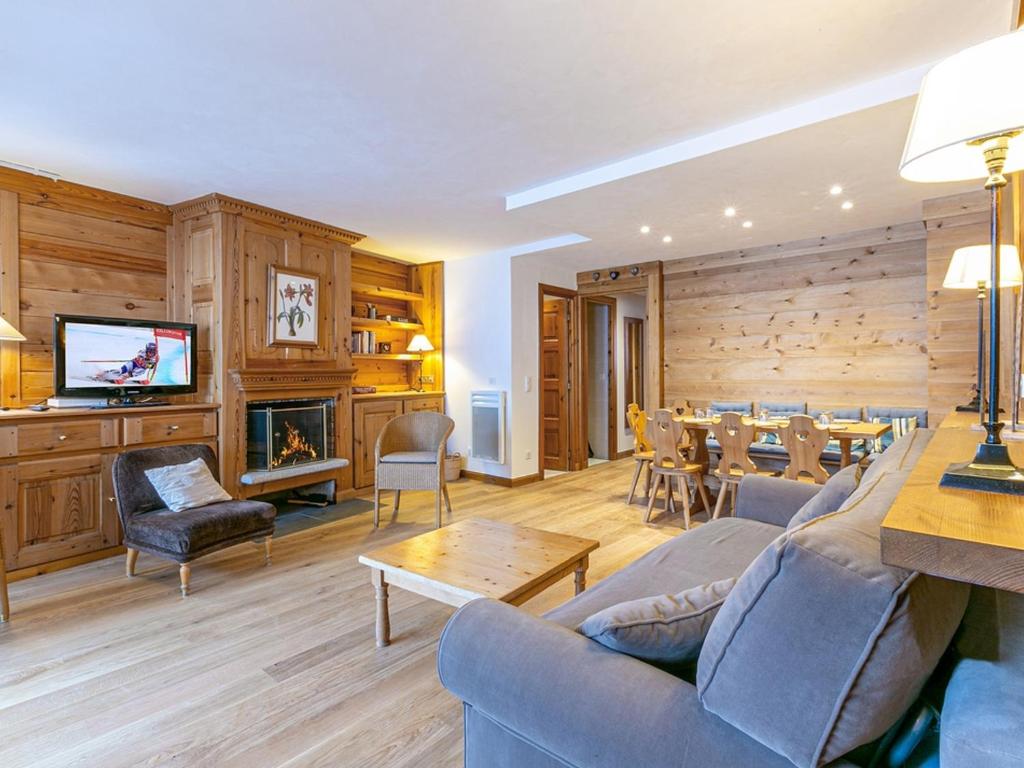 un salon avec un canapé et une salle à manger dans l'établissement Appartement skis aux pieds avec balcon, cheminée et parking - Méribel - FR-1-613-3, à Méribel