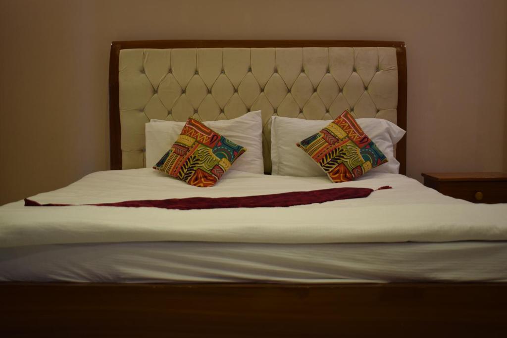 a bed with two pillows on top of it at City Seasons Hotel Murree in Murree