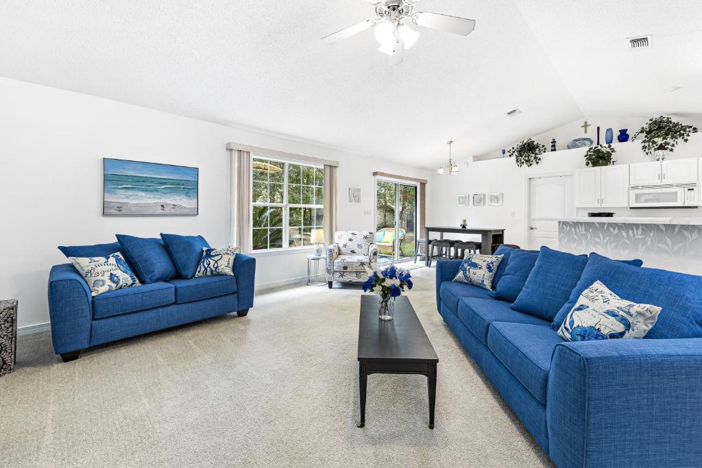 una sala de estar con 2 sofás azules y una mesa. en Charming Pensacola House with All Needed Essentials, en Perdido Beach