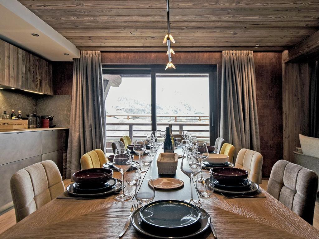 a dining room table with chairs and a large window at Appartement de luxe, skis aux pieds, Méribel - FR-1-613-39 in Méribel
