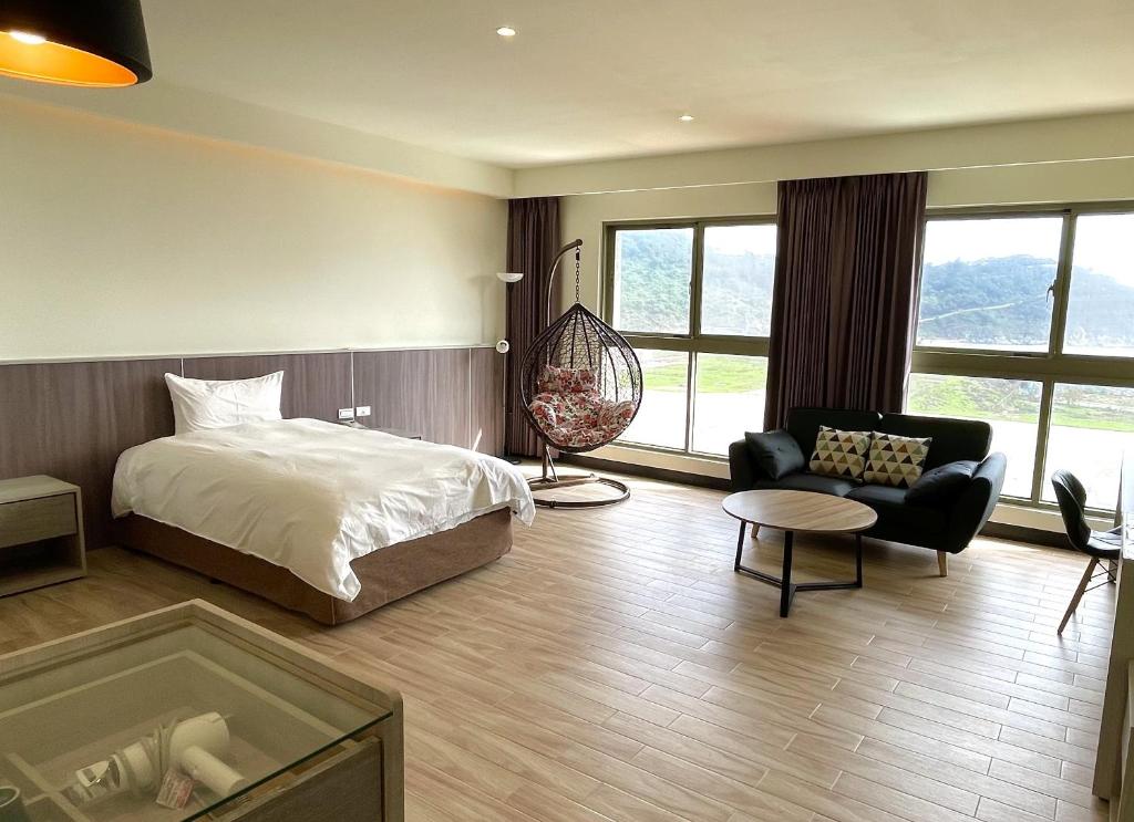 1 dormitorio con 1 cama, 1 sofá y 1 silla en Long Fu Hotel en Beigan