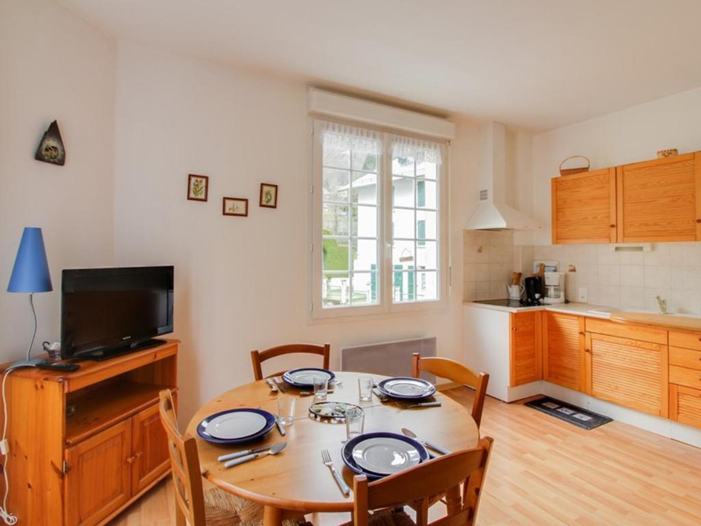 une cuisine et une salle à manger avec une table et des chaises dans l'établissement Appartement T2 avec terrasse, coin nuit, parking et proximité télécabine - 4 pers. - FR-1-401-66, à Cauterets