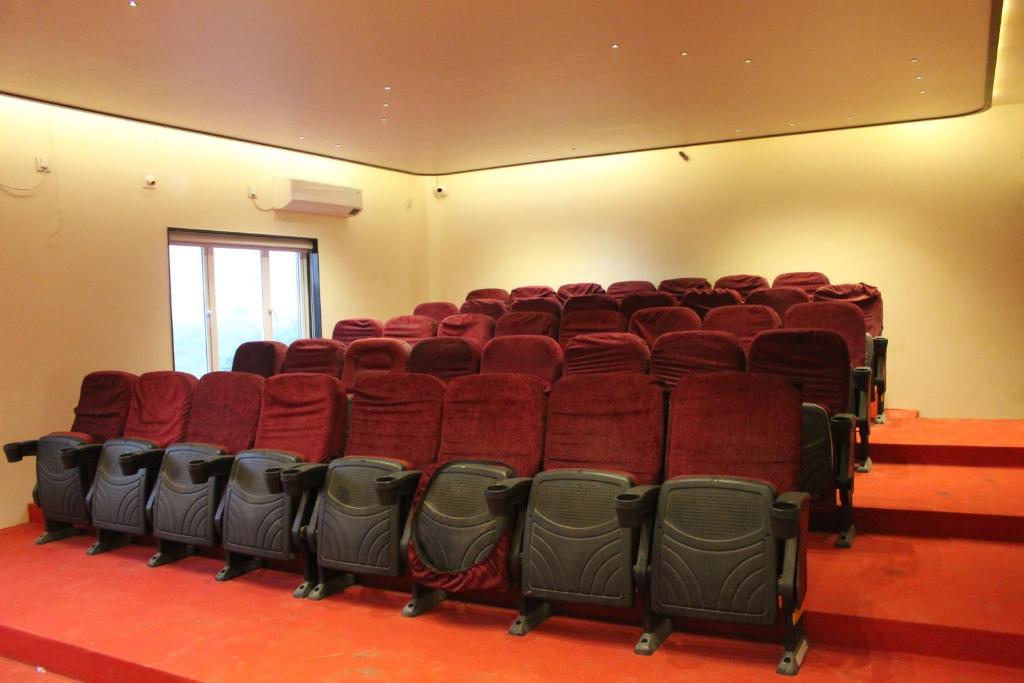 an empty auditorium with red seats in a room at Flamingo Club and Resort Una 3 Km Away from Diu Check Post in Diu