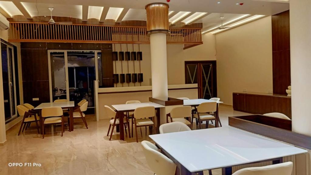 a restaurant with tables and chairs in a room at Flamingo Club and Resort Una 3 Km Away from Diu Check Post in Diu