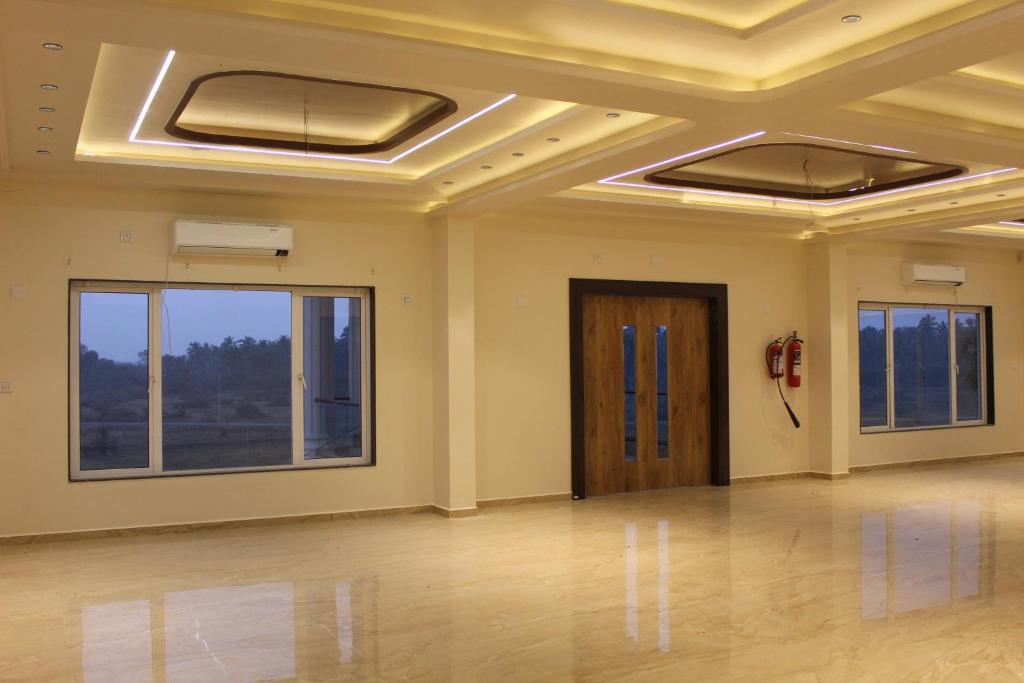 a large room with a ceiling with windows and a door at Flamingo Club and Resort Una 3 Km Away from Diu Check Post in Diu