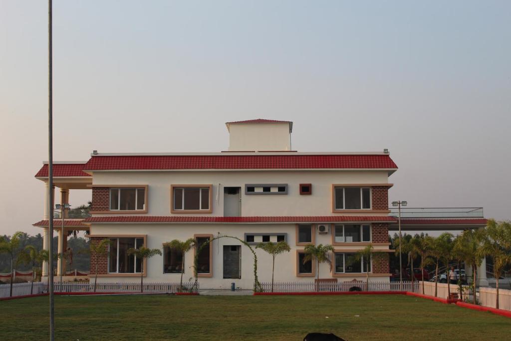 a large white building with a red roof at Flamingo Club and Resort Una 3 Km Away from Diu Check Post in Diu