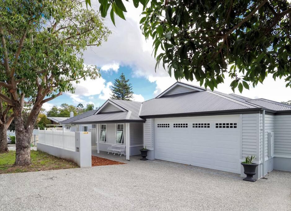 une grande maison blanche avec un garage dans l'établissement New Home~close to Airport & Swan Valley inc B/fast 1st Morning~, à Perth