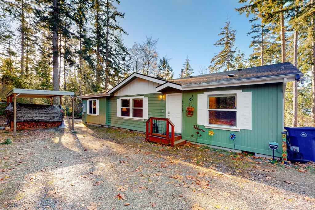 una casita verde y blanca en el bosque en Skagit Bay Hideaway, en La Conner