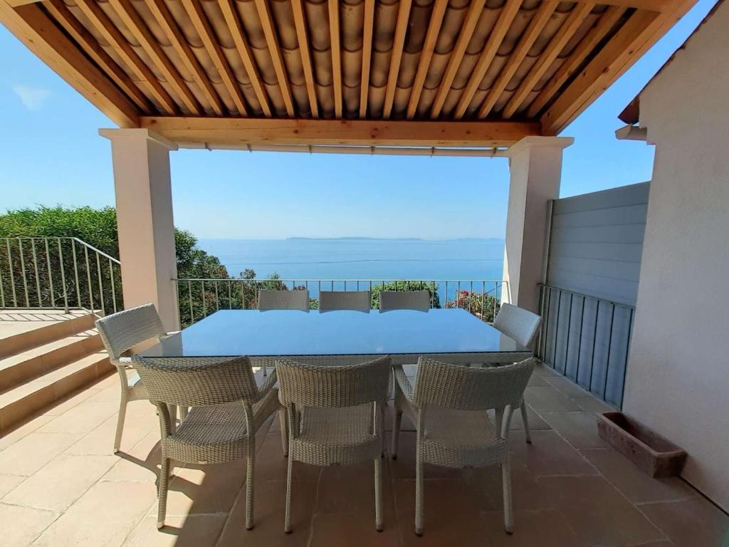a table and chairs on a patio with a view of the ocean at Maison Rayol-Canadel-sur-Mer, 5 pièces, 9 personnes - FR-1-308-142 in Rayol-Canadel-sur-Mer