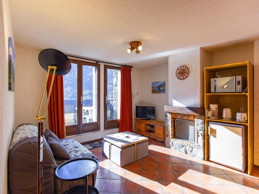 un salon avec un canapé et une cheminée dans l'établissement Duplex T3 à Esquièze-Sère, balcon, wifi et parking - FR-1-402-128, à Esquièze - Sère