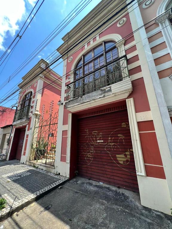 un edificio rojo y blanco con garaje en Hotel Casa do Visconde, en Manaus