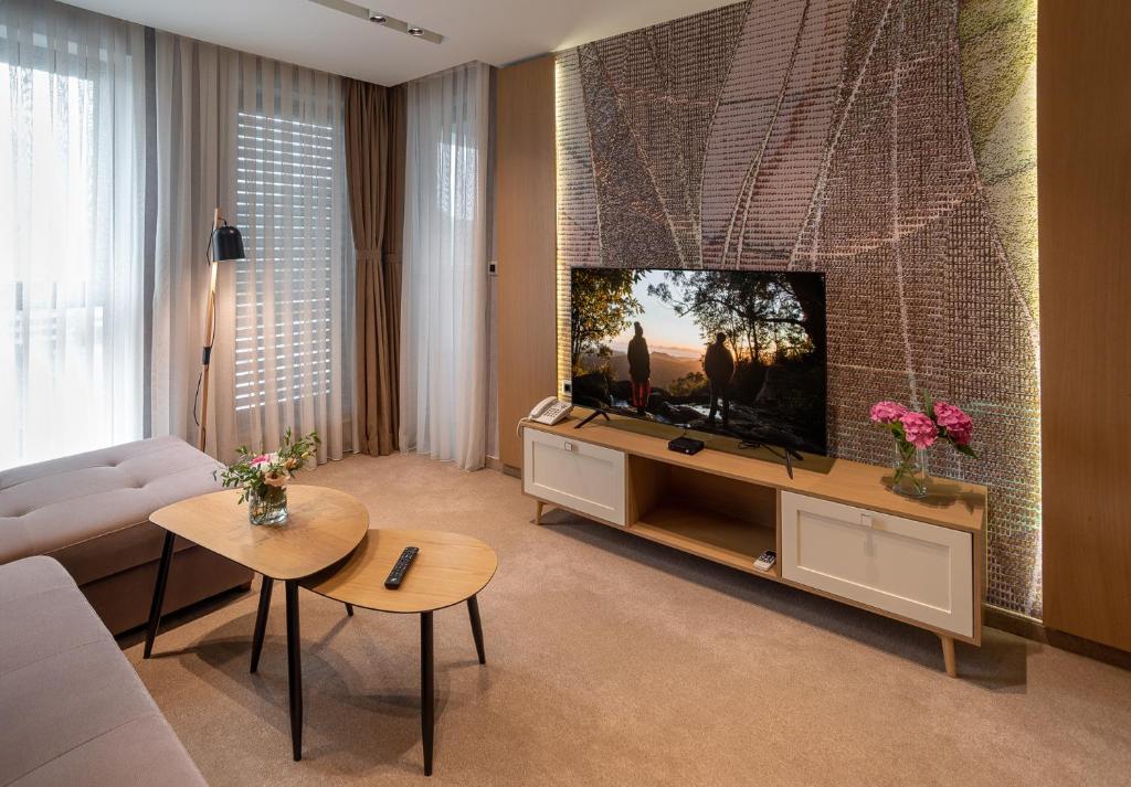 a living room with a flat screen tv on a wall at City Park Inn Apartment Cortona in Plovdiv