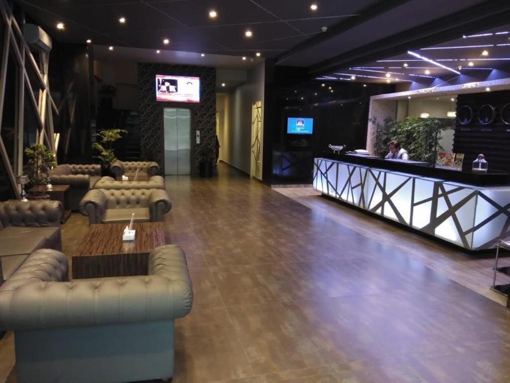 un vestíbulo con sofás y un bar en un edificio en West Inn Hotel Faisalabad, en Faisalabad