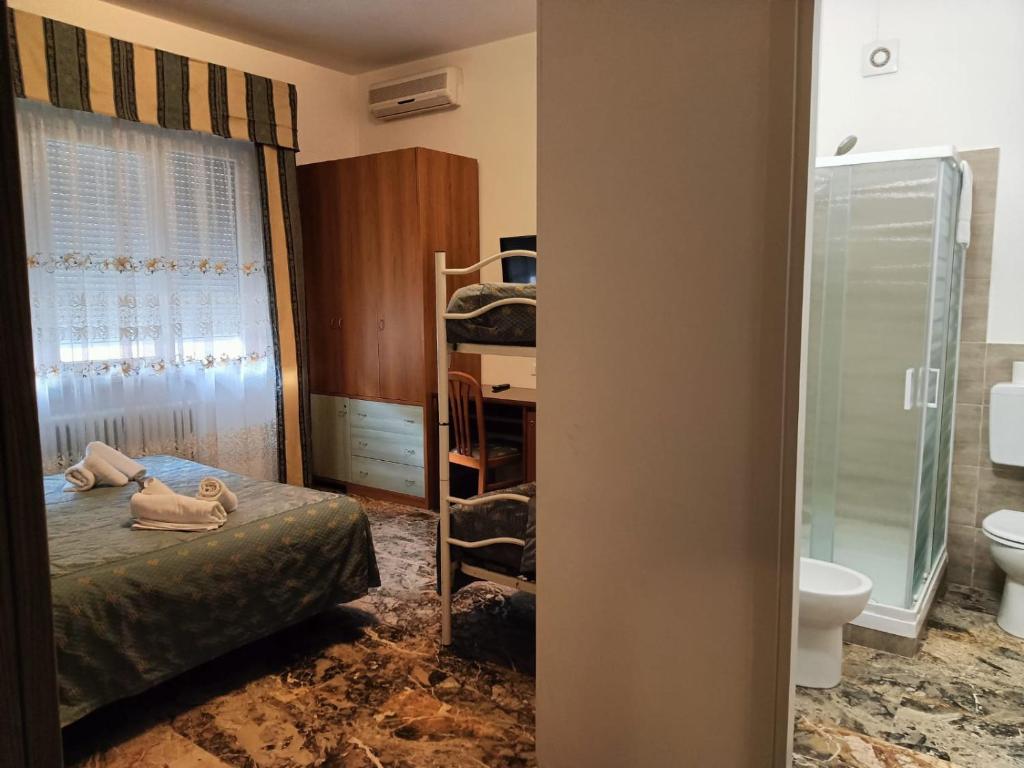 una camera con letto e un bagno con servizi igienici di Domus Cesena a Cesena