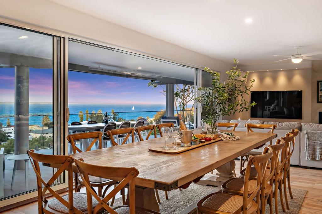 a dining room with a table and a view of the ocean at Phuza Maningi 17 Myan Close in Corlette
