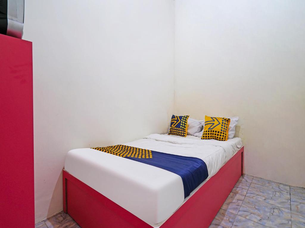 małe łóżko w pokoju z poduszkami. w obiekcie SPOT ON 91993 Pondok Hs Padalarang Syariah w mieście Padalarang