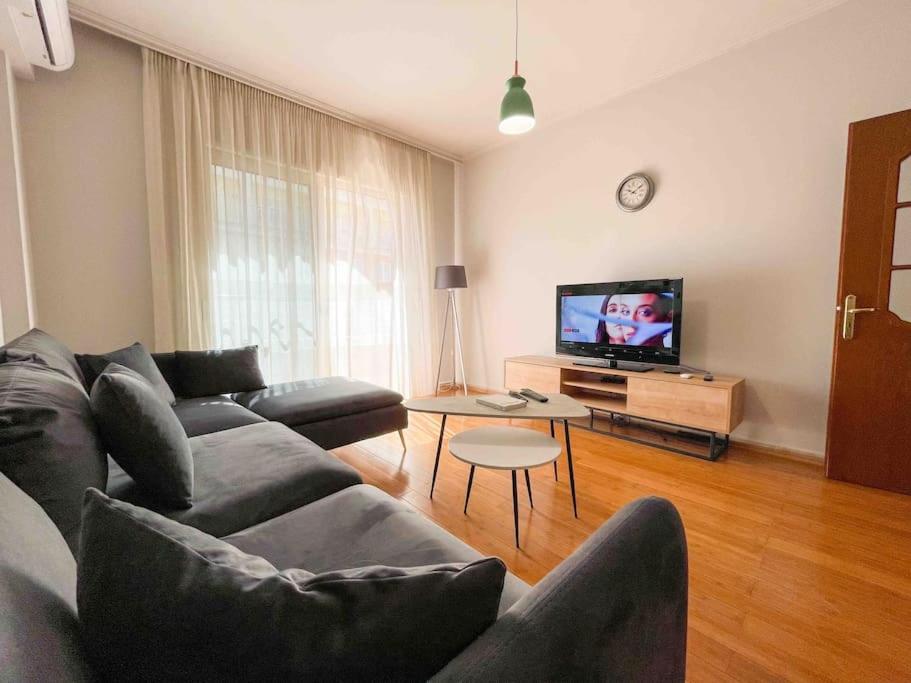 uma sala de estar com um sofá e uma televisão em Downtown Flat near Center with 24h Self Check-In em Tirana