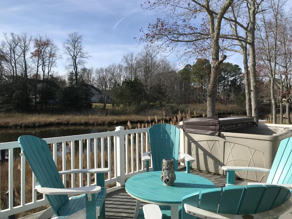 2 Stühle und ein Tisch auf einer Terrasse mit einem Boot in der Unterkunft Turtle Shores in Ocean Pines