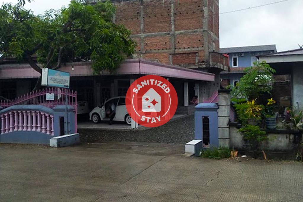 un edificio con una señal roja delante de él en OYO 92002 Wisma Samudra, en Pangkajene