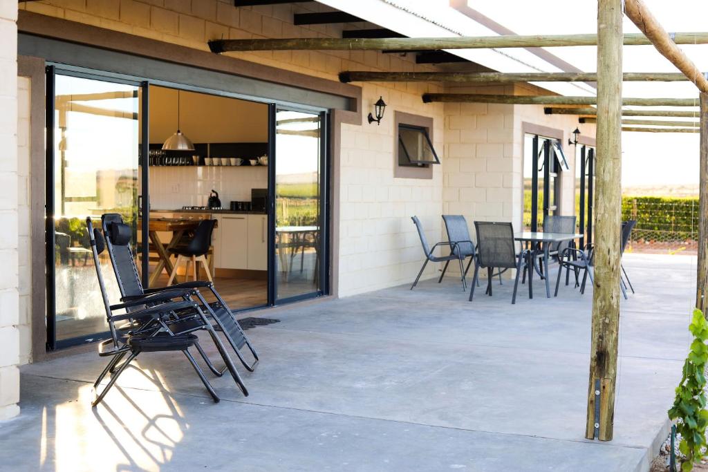 un patio con sillas y una mesa. en STEYNMOND COTTAGE en Kakamas