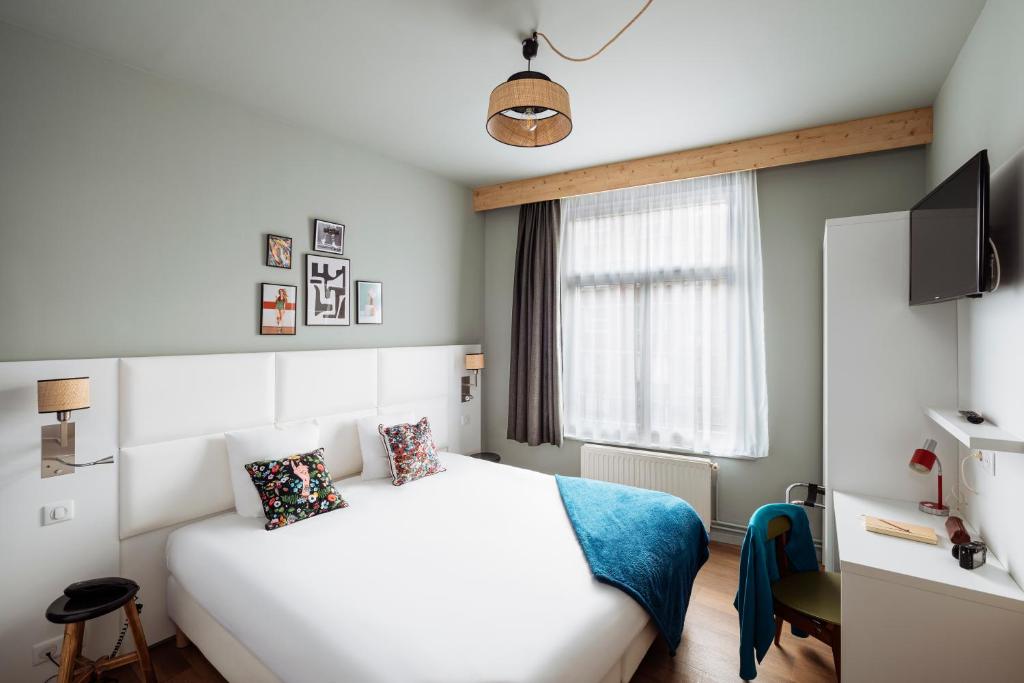 een slaapkamer met een wit bed en een raam bij greet hotel Lille Gare Flandres - Groupe Accor in Lille
