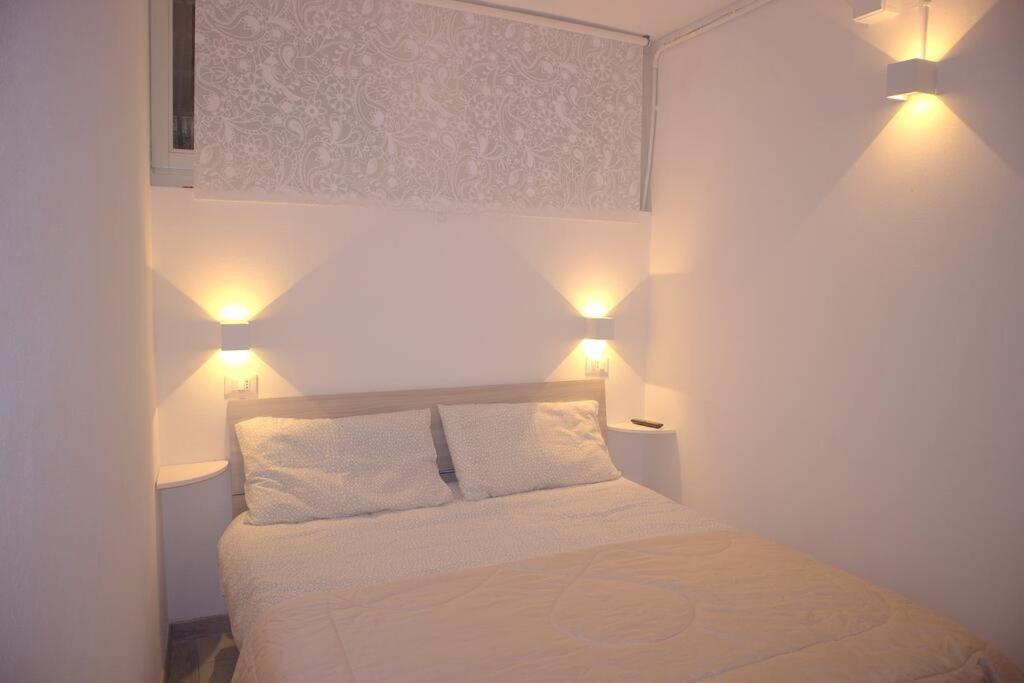 - une chambre avec un lit et deux lumières au-dessus dans l'établissement Vittoria Apartment, à Venise