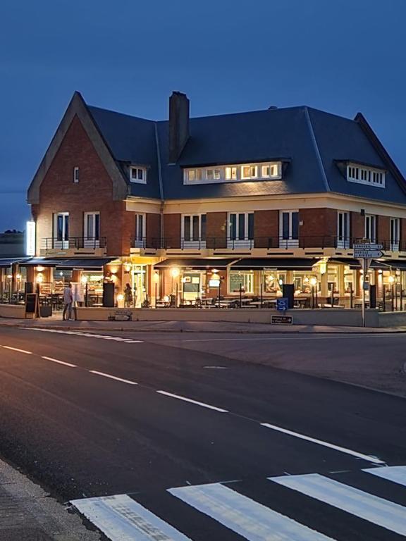 un gran edificio en una calle de la ciudad por la noche en L'Huitrière en Quiberville