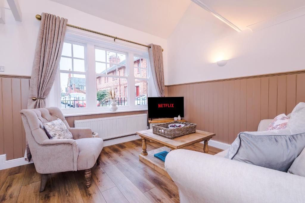 sala de estar con 2 sillas y TV en Country Charm Cottage Sleeps 4 & Free Parking en Chester